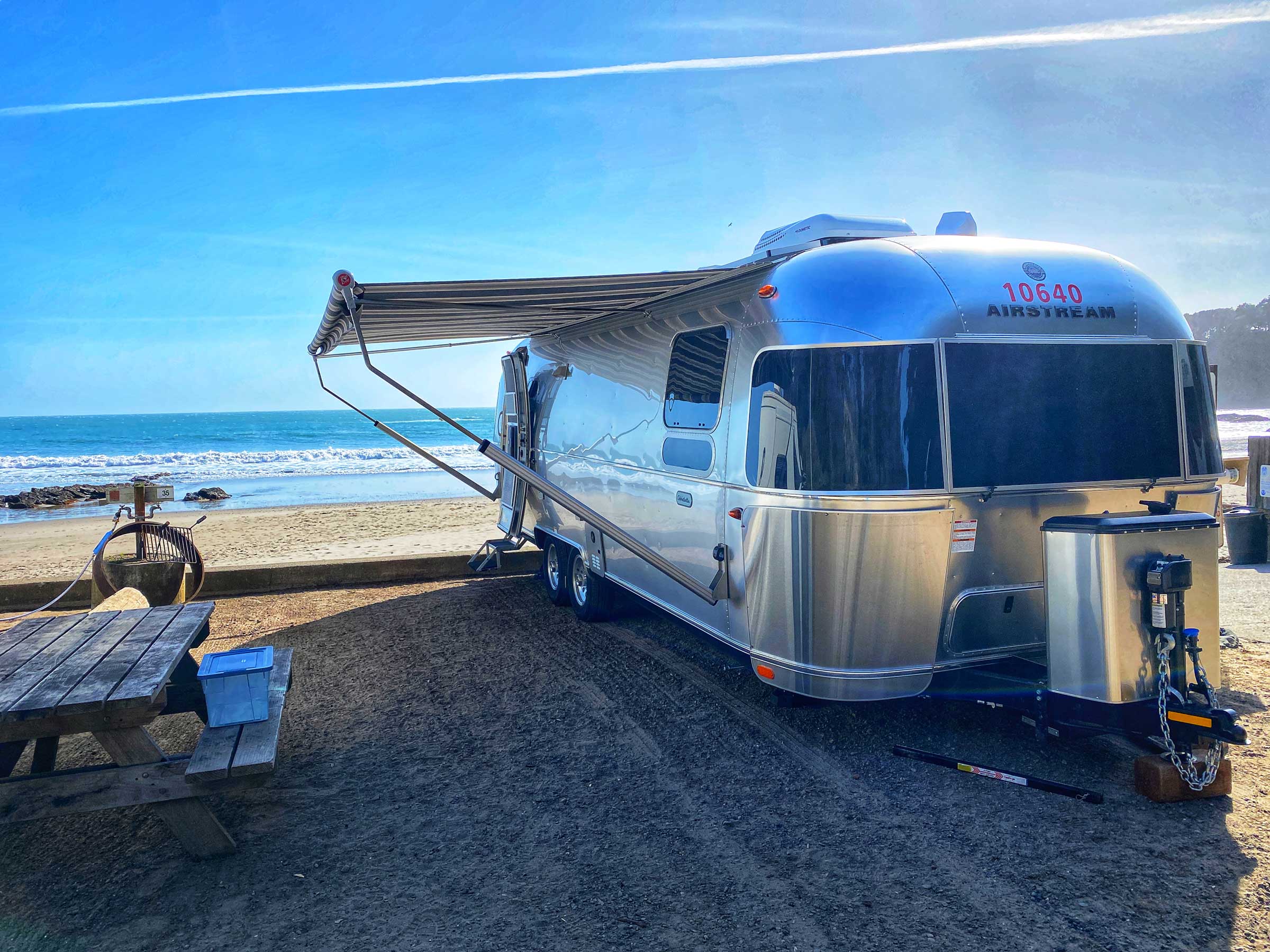 Airstream parked at the ocean with an awning extended